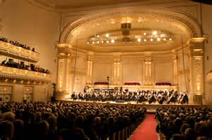 the right side of the Carnegie Hall, a classical music concert, showing the red carpet isle and many seats.